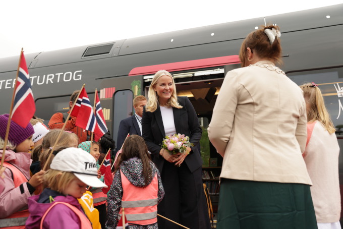 Kronprinsessen ble møtt med blomster og flagg på perrongen på Alvdal stasjon. Foto: Amanda Pedersen Giske / NTB