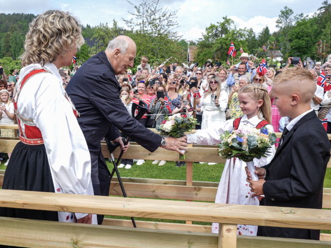 Niåringane Ella Tveit og Mikkel Råna ønska Kongeparet velkommen med blomstrar. Foto: Lise Åserud, NTB